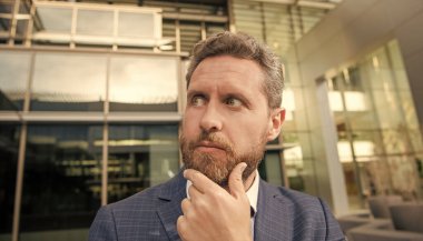 karar vermek. Formalite icabı düşünceli bir iş adamı. İş sorunu. Takım elbiseli düşünceli bir adam. Yönetici yöneticisi duygularını ifade ediyor. Olgun sakallı patron portresi.