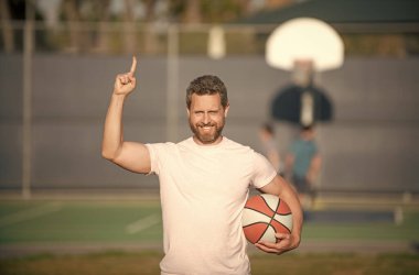 Mutlu kaslı erkek sporcu basketbolcu parmak kaldırdı açık havada top, spor.