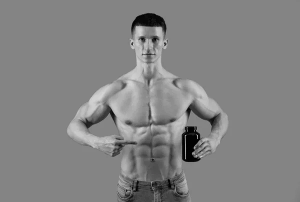 Suplementy Warte Wzięcia Człowiek Bez Koszuli Wskazuje Palcem Proteinową Butelkę — Zdjęcie stockowe