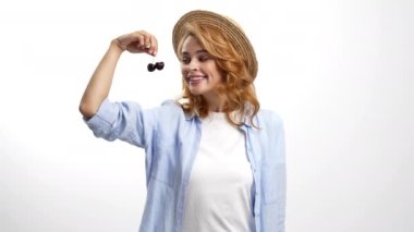 Yazlık şapkalı mutlu kız taze vişneli meyve ve vitamin yiyor..