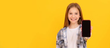 Mutlu çocuk, modern akıllı telefon ekran sunar. Fotokopi alanı için, reklam için. Telefonlu çocuk portresi, yatay poster, kopyalama alanı olan afiş