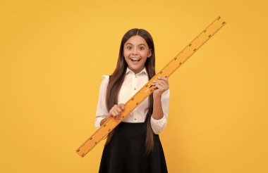 Cebir ve geometri. Çocuk matematik okuyor. Boyutunu ölçün. Trigonometri kırtasiyesi. Ölçme ve ölçme. Çocuk eğitimi. Matematik. şaşırmış genç kız cetvel tutuyor. Okula geri dön..