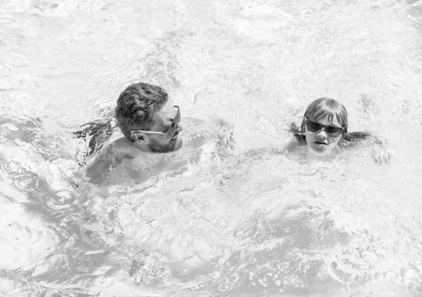 happy family of daddy and kid having fun in summer swimming pool, swim.