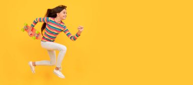 Koş ve atla. Mutlu enerjik genç kaykaycı kız kaykayla, pennyboard 'la atlıyor. Gündelik ergen çocuk posteri. Başlık, kopyalama alanı