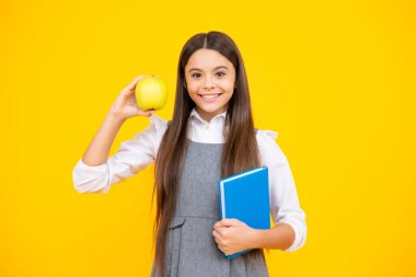 Liseli kızın elinde sarı izole edilmiş stüdyo geçmişi ile ilgili defter ve kitap var. Okul ve eğitim kavramı. Okul üniformalı ergen kız.