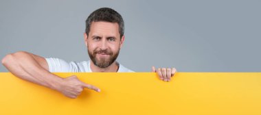 Yenilik bilgisi sunuyorum. Sarı kağıdın arkasındaki erkek. Pazarlama tasarımın için. İnsan yüzü portresi, kopyalama alanı olan pankart