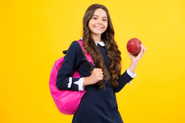 Back to school. Teenager school girl with backpack hold aplle ready to learn. School children with school bag on isolated yellow studio background