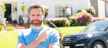 Torbacı adam arabayı ve yeni evi işaret ediyor. İnsan yüzü portresi, kopyalama alanı olan pankart