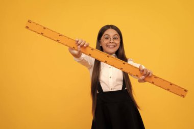Boyutunu ölçün. Trigonometri kırtasiyesi. Ölçme ve ölçme. Çocuk eğitimi. Matematik. Neşeli genç kız cetvel tutuyor. Okula dönüyorum. Cebir ve geometri. Matematik okuyan çocuk..