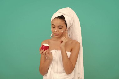 Banyo kulesinde genç bir çocuk cilt kremi sürüyor..