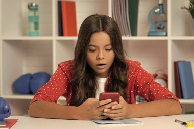 Şaşırmış çocuk kıvırcık saç mesajı sınıfta telefonda, mesaj....