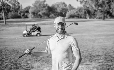 Yaz etkinliği. Profesyonel açık hava sporu. Profesyonel golf sahasında erkek golfçü. Golf sopasıyla şapkalı golfçünün portresi. İnsanların yaşam tarzı. Yeşil çimlerin üzerinde neşe dolu adam.