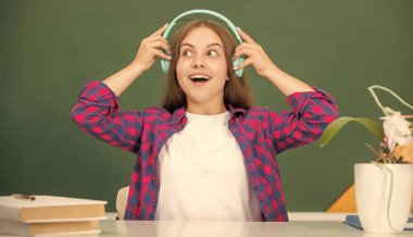 Yeni teknoloji. Çocukluk gelişimi. Modern kulaklıklı çocuk. Online eğitim. Okula dönüyorum. Kulaklıklı ergen kız hayrete düştü. Müzik aşığı. Müzik dinle. kablosuz kulaklık aygıtı aksesuarı.