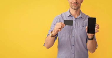 Kesilmiş adam akıllı telefon ve kartvizitini fotokopi alanı ve online bankacılık ile gösteriyor.