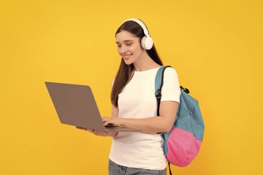 İletişim teknolojisi. Sırt çantalı kadın laptopta sohbet ediyor. İnternetten al. Okula dönüyorum. Etkileyici bloglar. Kulaklıklı gülümseyen kız. Kablosuz kulaklıkla giyin. modern eğitim.