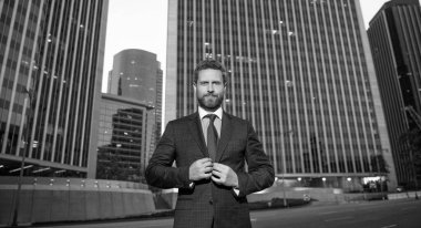 Yönetici ofis dışında. Erkek resmi moda. Kendine güvenen sakallı patron. Giyim kuşamında moda bir iş adamı. İş başarısı. Takım elbiseli başarılı bir adam..