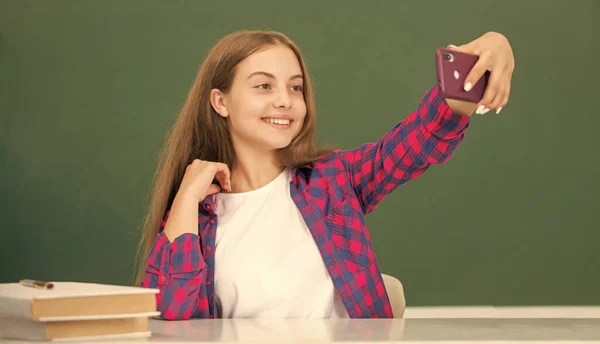 快乐的孩子在黑板 肖像画的教室里用智能手机自拍 — 图库照片