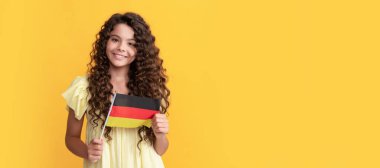 Gülümseyen uzun kıvırcık saçlı çocuk Alman bayrağı taşıyor, Almanya. Ayrı çocuk yüzünün yatay posteri, afiş başlığı, kopyalama alanı