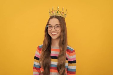 Tacın içinde mutlu bir genç kız. Kendine güvenen kraliçe. Kendini beğenmişlik taslıyor. Tacın içindeki kibirli prenses. gururlu çocuk gülümsüyor. Gözlüklü egoist çocuk diyabet takıyor. Kibir ve bencillik. Zafer portresi.