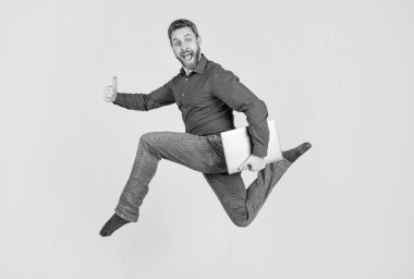 Enerjik patron bilgisayarı tutuyor. Baş parmak hareketi. Bilgisayarda çalışan zıplayan iş adamı. Başarı yolunda koş. Programcı bilgisayar kullansın. Girişimci koşuyor ve acele ediyor. çevik iş.