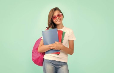 Okul çantalı bir öğrenci. Lisede. Mutlu genç kız sırt çantası ve defter taşıyor. Okula dönüyorum. Bilgi günü. Eğitim. Gözlüklü çocuk defter tutuyor. 1 Eylül çocukluğu..
