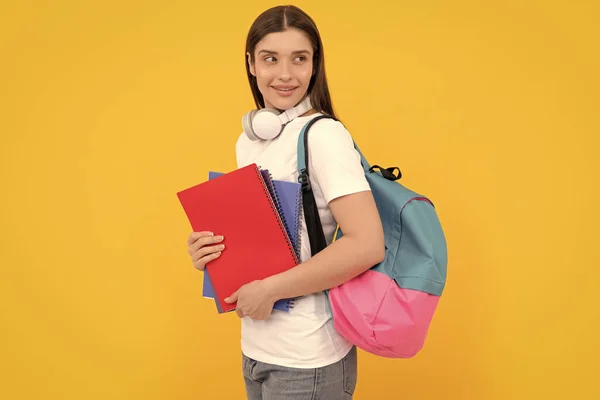 現代教育の概念です 笑顔でノートを持ってる 黄色い背景にノートを持ってる女の子 コピーとヘッドフォン付きの私立教師です 学校に戻ると — ストック写真