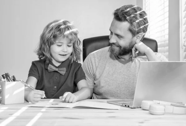 bearded dad or school private tutor teaching boy son with modern laptop, family.