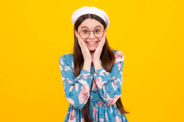 Mutlu ergen, pozitif ve gülümseyen duygular. Şok olmuş ergen portresi sarı arka planda izole edilmiş. Şaşırmış genç kız.