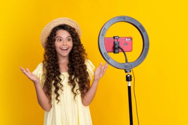 Genç blogcu çocuk blog için video kaydediyor. Video bloğu için kameranın önünde konuşan genç kız. Blogcu olarak çalışan bir genç, blog için video dersi kaydediyor. Mutlu genç, pozitif ve gülümsüyor.