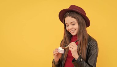 Neşeli çocuk yüz pudrası sür. Genç kızlar kızarır. Makyaj fırçası olan çocuk. Günlük alışkanlık ve kişisel bakım. Cilt güzellik kozmetiği. Karşınızda kadın kozmetik ürünü..