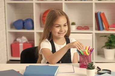 Mutlu çocukluk. Neşeli çocuk ödevlerini kitapla yapacak. Eğitim. Lisede. Kırtasiyeli liseli kız. Okula dönüyorum. Genç kız çalışmaya hazır..