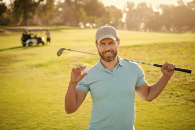 Şapkalı mutlu golfçünün portresi golf topunu ve golfü gösteriyor..