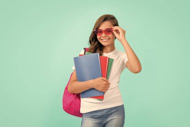 Mutlu liseli kız sırt çantası ve not defteri taşıyor. Okula dönüyorum. Bilgi günü. Eğitim. Gözlüklü çocuk defter tutuyor. 1 Eylül çocukluğu. Okul çantalı öğrenci ödevlerini yapacak..