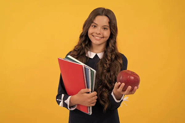teen girl hold apple after study. healthy childhood. happy kid going to do homework. teenager student hold copybooks. education in high school. schoolgirl with apple lunch. back to school.