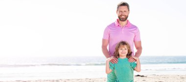 Baba ve oğulun yaz deniz sahilindeki bayrağı. Mutlu baba ve oğulun yaz plajındaki aile portresi. Kopya alanı, aile..