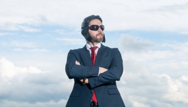 Takım elbiseli kendine güvenen iş adamı ve arka planda pilot şapkası.