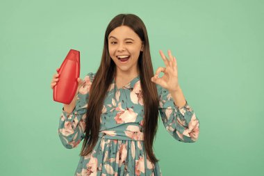 Mükemmel cilt losyonu. Gençler için kozmetik ürünler sunuyorum. Duş jeli çocuk. Mutlu kız şampuan şişesini tutuyor. Saç kremi kullanan bir çocuk. Günlük alışkanlıklar ve kişisel bakım. Güzel cilt bakımı. Tamam.