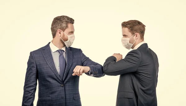 businessmen not shaking hands. social distancing during coronavirus. boss and employee in medical mask. covid19 prevention. successful deal of men partners. business colleague bumping elbows.