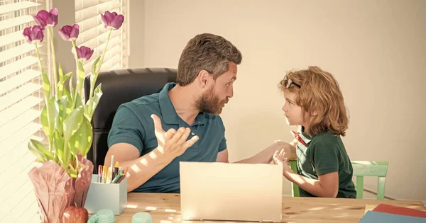 bearded dad or school private tutor teaching boy son with modern laptop, parenting.