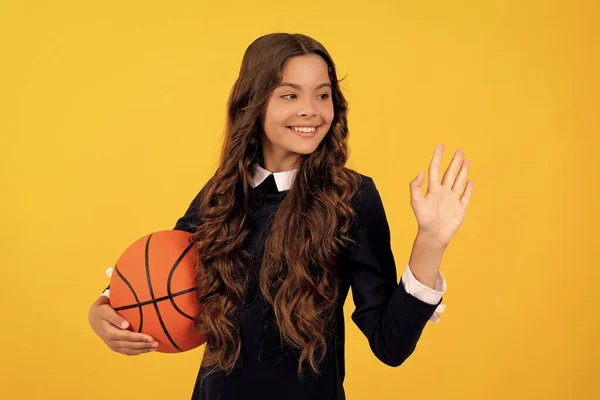 Szczęśliwy Nastolatek Dziewczyna Trzymać Koszykówka Piłka Machając Cześć Żółtym Tle — Zdjęcie stockowe
