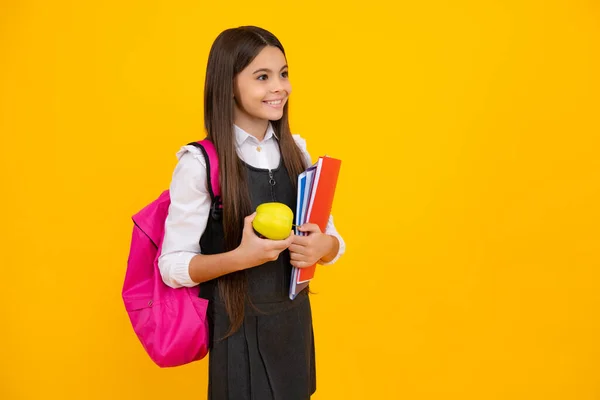 带着书包书包的女学生 拿着首字母和黄色孤立的工作室背景的书 儿童学校和教育概念 — 图库照片