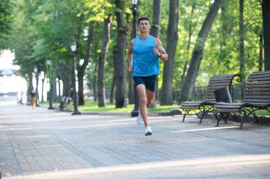 Spor giysileriyle koşan atletik bir adam. Anaerobik yük.