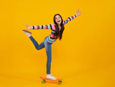 Güzel ve moda genç kız kaykayla poz veriyor. Genç sokak modası yaşam tarzı. Mutlu ergen, pozitif ve gülümseyen genç kız duyguları