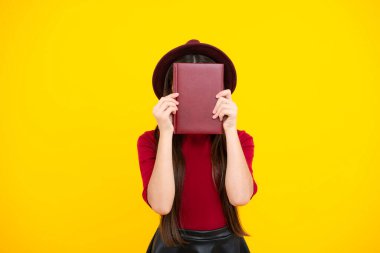 Kopya kitabı olan liseli kız izole edilmiş arka planda poz veriyor. Edebiyat dersi, ilkokul. Entelektüel çocuk okuyucu