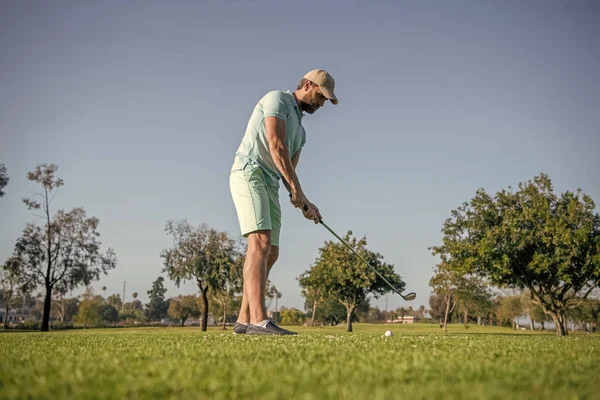 active golfer in cap with golf club, golfing.