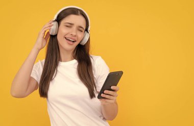 İletişim teknolojisi. Akıllı telefondan kadın sohbeti. Müzik dinliyordum. Etkileyici bloglar. Şarkı söyleyen kulaklıklı kız. Kablosuz kulaklıkla giyin. modern eğitim online.