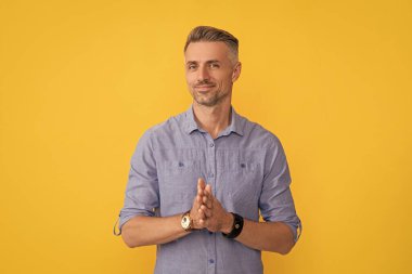Sarı arka planda kol saati olan gülümseyen adam, moda aksesuarı..