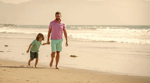 family day. daddy with kid boy on summer day. dad and child having fun outdoors. childhood and parenting. copy space. father and son running on summer beach. family travel weekend and vacation.