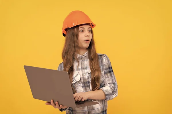 surprised teen girl in helmet and checkered shirt using computer, surprise.