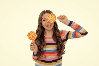 Beyaz arka planda izole edilmiş lolipop şekerli renkli kazaklı komik genç kız, karamel dükkanı..